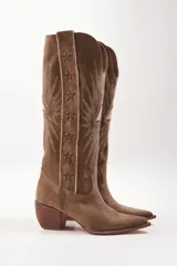 Botas texanas de cuero color marrón con bordados blancos en forma de estrellas y rayos.