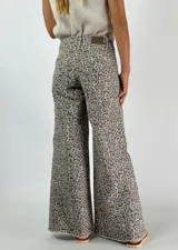 Pantalón jean de corte ancho con estampado animal print en tonos beige y gris.