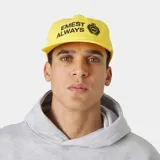 Gorra amarilla con visera curva, confeccionada en algodón. Cuenta con bordado frontal con el texto "EMEST ALWAYS" y un escudo distintivo en negro.