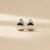 Aros tipo argolla pequeña en plata 925 con diseño bombé, superficie lisa y acabado brillante.