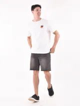 Remera verde claro de corte recto y mangas cortas, con estampado pequeño de palmeras y sol en el pecho.