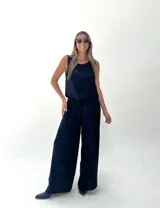 Conjunto de musculosa y pantalón palazzo color dorado brillante. La musculosa es sin mangas y el pantalón es de corte ancho con cintura alta.