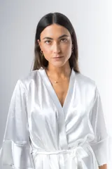 Bata corta color blanco de satén elastizado, con mangas tres cuartos con volados y lazo para atar en la cintura.