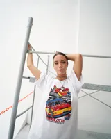 Remera blanca oversized de algodón peinado con estampa serigráfica de un auto de carreras.