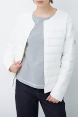 Campera acolchada tipo puffer en color beige, con diseño sin cuello y cierre frontal con botones a presión.