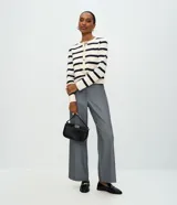 Cardigan de punto con diseño rayado horizontal en color blanco y rojo. Presenta escote redondo, manga larga, cierre frontal con botones dorados y bolsillos delanteros discretos. Posee una caída estructurada y acabado sofisticado.