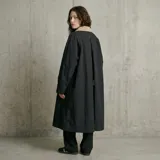 Chaqueta de gabardina color negro con largo midi, cuello en contraste color beige, cierre frontal con botones y diseño con tajo trasero.