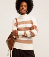 Suéter de punto pesado color blanco y marrón, con cuello alto y textura acanalada.