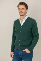 Cardigan de lana merino en color verde oscuro, con escote en V, cierre frontal de botones y dos bolsillos delanteros tipo parche.
