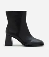 Bota de caña baja en cuero sintético color negro, con punta cuadrada y taco bloque de altura media con textura amaderada.