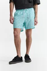 Short de baño celeste y azul con cintura elástica ajustable con cordón, dos bolsillos laterales y uno trasero. Confeccionado en tela ligera de secado rápido y logo bordado.