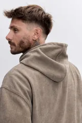 Buzo con capucha tipo canguro confeccionado en tela de corduroy color marrón. Presenta cordones blancos en contraste, bolsillo frontal tipo canguro y logo bordado sutil en el pecho.