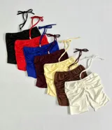 Top amarillo pálido con escote strapless, detalle de fruncido en el centro y abertura en el abdomen.