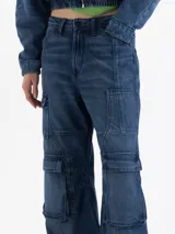 Pantalón de jean estilo cargo con corte holgado y tiro medio. Presenta múltiples bolsillos laterales con solapa, costuras reforzadas y un acabado de lavado azul clásico.