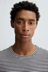 Camiseta de corte relajado con cuello redondo y manga corta, confeccionada en tejido de algodón y lino a rayas horizontales blancas y negras.