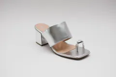 Sandalias de cuero color bronce con taco cuadrado y tira ancha sobre el empeine. Presentan un aro metálico plateado que separa el dedo gordo del resto.