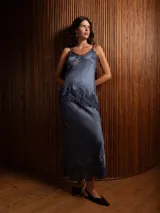 Pollera larga de satén color gris azulado, con corte al bies y detalle de encaje oscuro en el ruedo.