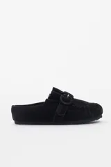 Slipper de gamuza negra con diseño destalonado, costura fruncida en la puntera y tira lateral con hebilla revestida.