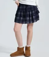 Short pollera de tiro medio con estampado de cuadros escoceses en tonos azul y gris. Presenta diseño de volados sobrepuestos y cintura con lazo ajustable.