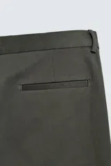 Pantalón chino de corte regular fit, confeccionado en tejido de algodón con elasticidad. Presenta bolsillos frontales, bolsillos traseros de vivo y cierre frontal con cremallera y botón.