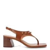 Sandalias de cuero color negro con taco medio ancho, diseño tipo thong con tira separadora de dedos y apliques de tachas semiesféricas doradas. Cuenta con tira ajustable en el talón con hebilla metálica dorada.