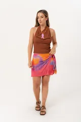 Minifalda multicolor con estampado abstracto en tonos naranja, rosa y violeta. Diseño cruzado con lazo lateral.