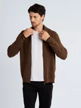 Campera de punto tipo cardigan con cierre frontal completo, cuello redondo y puños con detalle de contraste. Diseño de tejido liso y corte clásico.