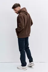 Buzo con capucha tipo canguro confeccionado en tela de corduroy color marrón. Presenta cordones blancos en contraste, bolsillo frontal tipo canguro y logo bordado sutil en el pecho.