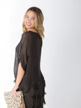 Vestido midi de seda italiana color negro, diseño dos en uno con capa superior de calce amplio, falda con volados y forro interior de algodón elastizado.