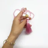 Japa Mala elaborado con 108 cuentas de cuarzo rosa de 6 mm de diámetro, dije gurú de madera y borla de hilo de seda color rosado.