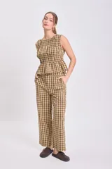 Pantalón de corte recto y tiro medio con estampado de cuadros vichy en tonos verde y beige. Cuenta con bolsillos laterales y cierre frontal.