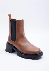 Bota marrón de símil cuero, con punta redondeada, pieza elastizada negra en los laterales y plataforma de 6cm.