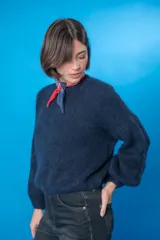 Sweater color beige de lana mohair y acrílico, con cuello redondo y mangas largas.