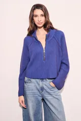 Sweater marrón de punto acanalado, con cuello alto, cierre frontal parcial con cremallera y manga larga.