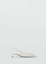 Zapato blanco con diseño troquelado, punta fina, tacón kitten y tira trasera.