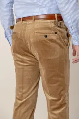 Pantalón de pana de corte recto custom fit, color marrón, con bolsillos laterales y cierre de botón y cremallera.