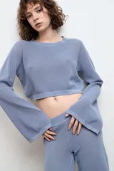 Pantalón celeste de punto, tiro bajo y corte recto.