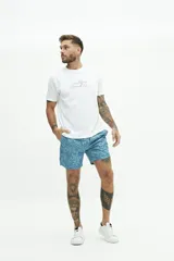 Short de baño con estampado floral en tonos azules, cintura elástica con cordón ajustable, bolsillos laterales y bolsillo trasero.