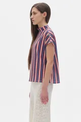 Blusa de rib a rayas verticales azules, rojas y blancas, de manga corta y cuello alto.