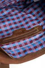 Bolso tipo tote bag color marrón con diseño capitonado de ondas, asas largas y placa metálica con el logo de la marca.
