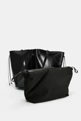 Bolso tipo shopper de efecto arrugado y acabado brillante en color negro, con detalles fruncidos en el centro, cordones colgantes en los laterales y doble asa para el hombro.