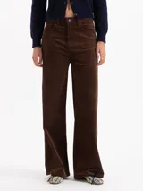 Pantalón de corte wide leg y tiro medio, confeccionado en corderoy color marrón. Presenta un diseño de cinco bolsillos con cierre frontal de botón y cremallera.