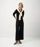 Blusa femenina de punto color blanco crema, con cuello polo y escote en V. Presenta detalles de biés negro contrastante en el cuello y los puños de las mangas largas.