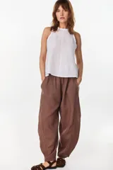 Blusa marrón de lino, sin mangas, con escote redondo y corte evasé. Presenta una costura vertical central en el frente y bajo asimétrico.