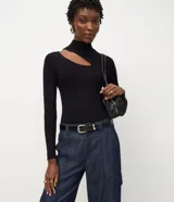 Blusa de punto acanalado color lila, con cuello alto, mangas largas y abertura en el hombro.