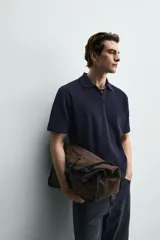 Polo de punto azul marino, de corte regular fit, con cuello solapa, abertura frontal en V y mangas cortas.