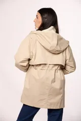 Campera tipo trench de nylon color negro, con capucha, cierre frontal y cordón ajustable en la cintura.