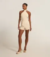 Mono corto color crema, con cuello halter y corte sastrero.