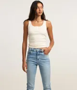 Pantalón bootcut de tiro alto en denim azul claro, ceñido en caderas y muslos con corte acampanado hacia el bajo y detalle de pequeña abertura lateral en los tobillos. Cuenta con bolsillos y cierre tradicional con botón y cremallera.