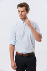 Camisa celeste de manga larga confeccionada en algodón, con cuello camisero, cierre frontal de botones, bolsillo en el pecho y diseño de cuadros sutiles.